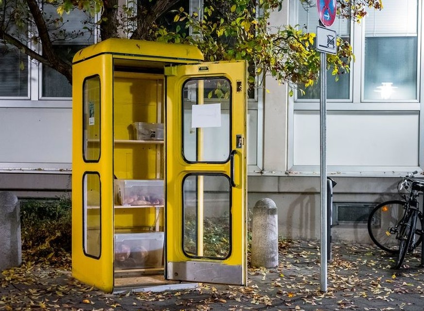 ARCHIV - 09.12.2022, Bayern, Coburg: Eine Foodsharing Station in einer gelben Telefonzelle ist mit Brötchen und Borten befüllt. (zu dpa: «Essen aus Telefonzelle: Neuer Foodsharing-Standort in Coburg») ...