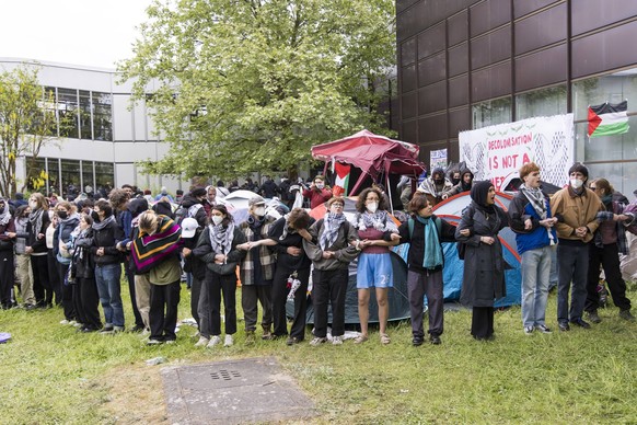 Activists form a human chain in an attempt to protect their tents during the occupation of the courtyard of the Free University of Berlin by pro-Palestinian activists. Some of the approximately 150 ac ...
