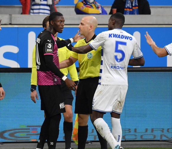 Nachdem Aaron Opoku rassistisch beleidigt wird, versuchen ihn Schiedsrichter Nicolas Winter und Duisburgs Leroy Kwadwo zu beruhigen. 