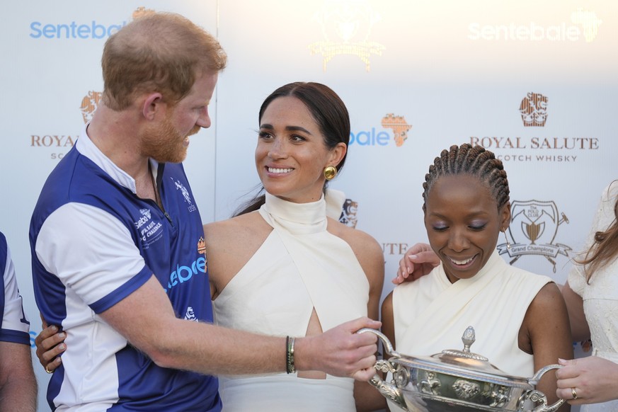 12.04.2024, USA, Wellington: Meghan Markle, Herzogin von Sussex, blickt zu ihrem Ehemann, dem britischen Prinz Harry, während der Preisverleihung für die Royal Salute Polo Challenge 2024 zugunsten von ...