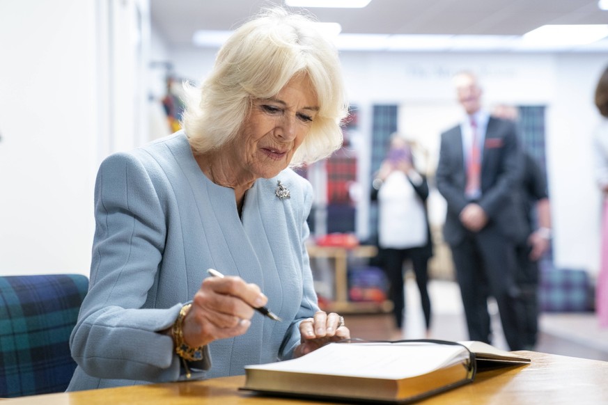 King visits Scotland for Holyrood Week Queen Camilla signs the visitor book during a visit to Lochcarron of Scotland at the Waverley textile mill in Selkirk, in the Scottish Borders, as part of the fi ...