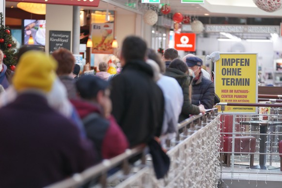 Zahlreiche Menschen stehen in Berlin Schlange vor einem Impfzentrum im Einkaufscenter.