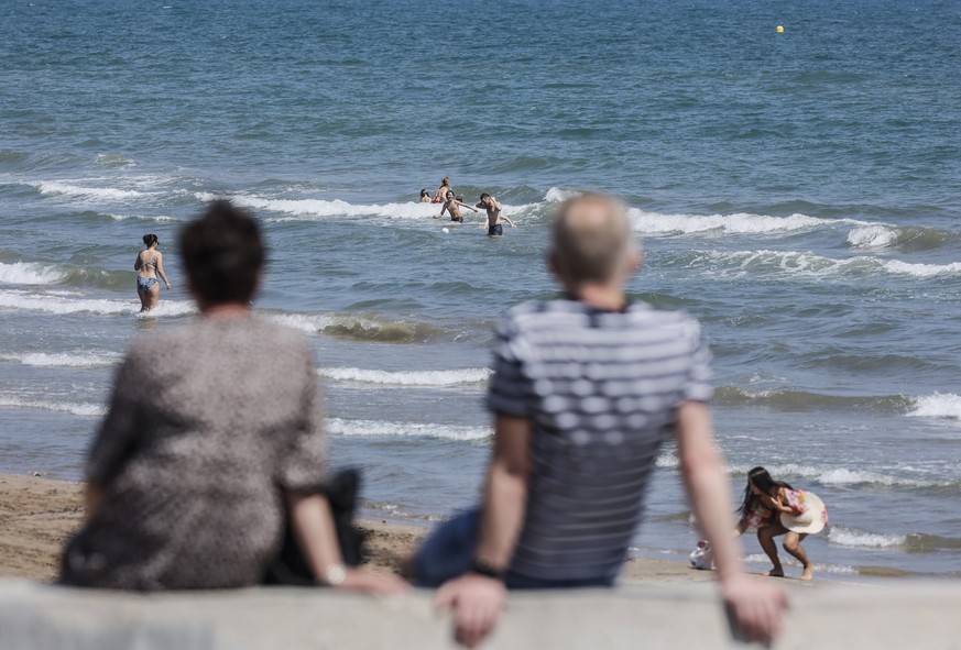 26.04.2023, Spanien, Valencia: Menschen baden am Strand von Malvarrosa in Valencia. Die Temperaturen in der Region Valencia werden in dieser Woche sommerliche Werte erreichen, in einigen Teilen der Re ...