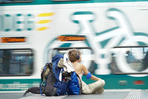 Eine Reisende sitzt am Hauptbahnhof am Bahnsteig und wartet auf ihren Zug. Die Neun-Euro-Ticket-Aktion hat über Pfingsten für einen Ansturm auf Bahnhöfe und Züge gesorgt.