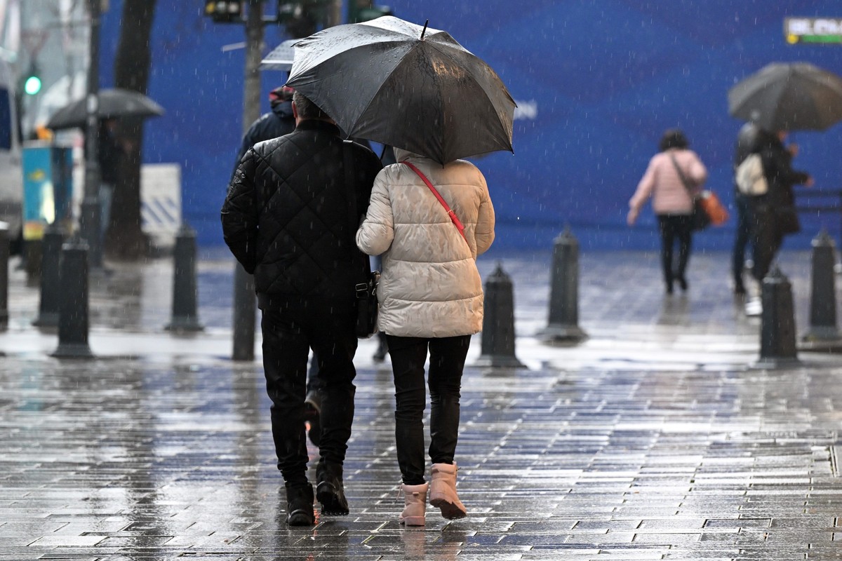 11.03.2024, Nordrhein-Westfalen, Düsseldorf: Passanten gehen unter ihrem Regenschirm über die Königsallee. Mit trübem Regenwetter beginnt in Nordrhein-Westfalen die neue Woche. Dafür können sich die M ...