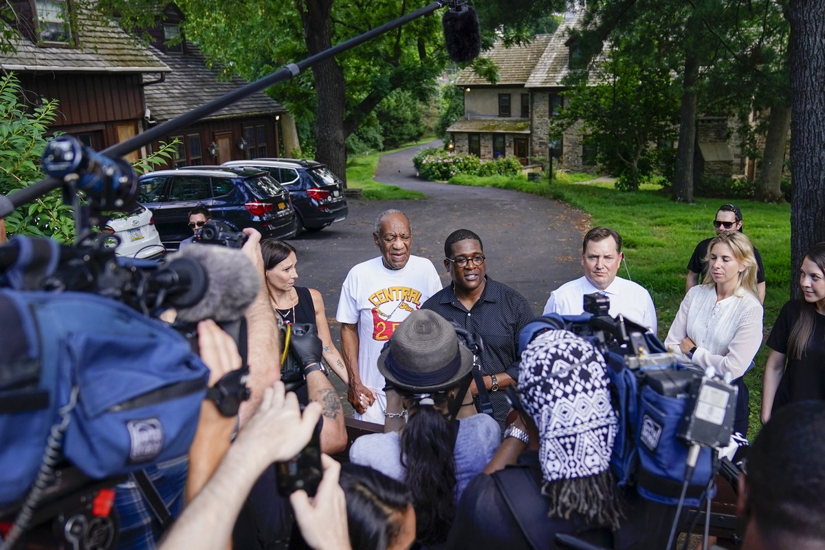Bill Cosby, center, and spokesperson Andrew Wyatt, right, approach members of the media gathered outside the home of the entertainer in Elkins Park, Pa., Wednesday, June 30,2021. Pennsylvania's h ...