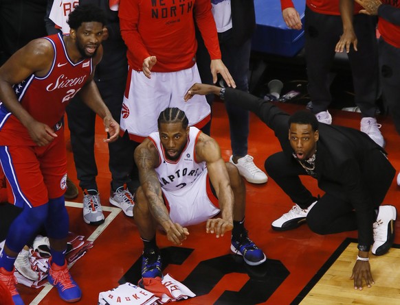 May 12, 2019; Toronto, Ontario, CAN; Philadelphia 76ers center Joel Embiid (21) and Toronto Raptors forward Kawhi Leonard (2) wait for the game winning basket by Leonard to drop in during game seven o ...