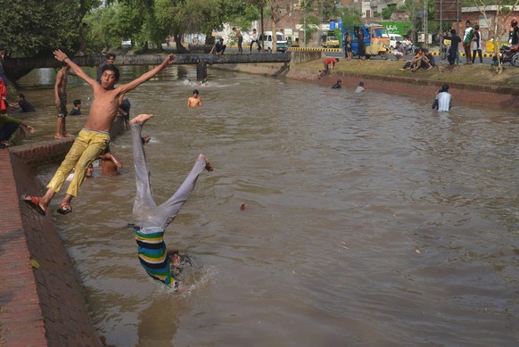 Diese Jungs in Lahore in Pakistan versuchen, der Hitze durch ein Bad im Kanal zu entgehen