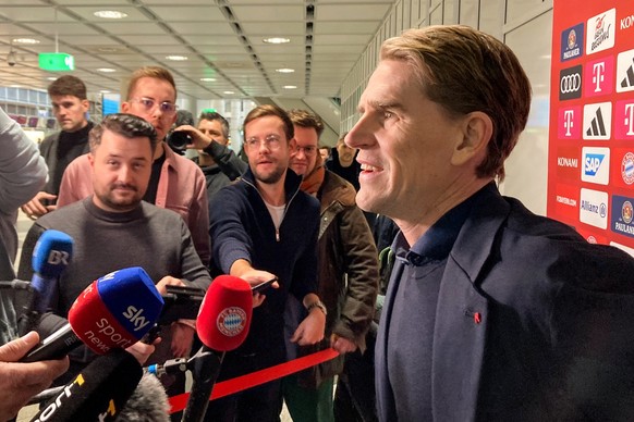 11.12.2023, Bayern, München: Fußball: Champions League, vor dem Spiel Manchester United - Bayern München, Abflug am Münchner Flughafen. Christoph Freund (r), Sportdirektor FC Bayern München, spricht z ...