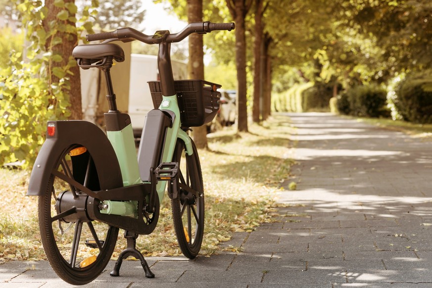 Bike Rent e-bicycle in Park Street. Electric Bicycle sharing Service. Electric bike in urban Space Background.