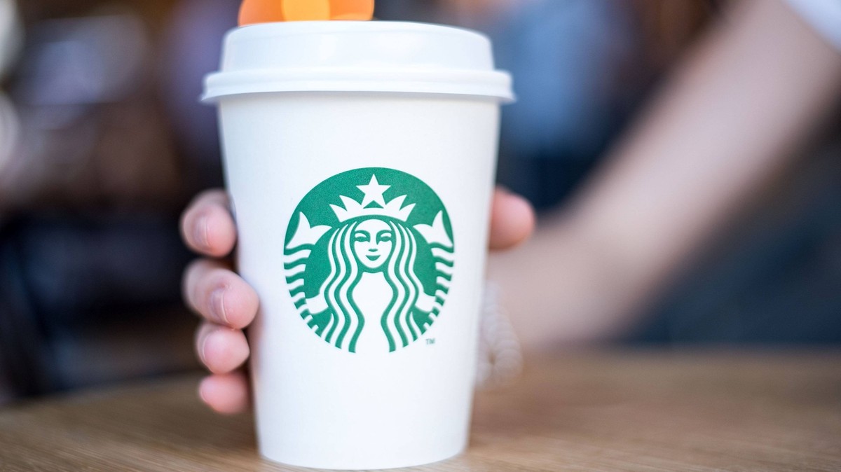 03.10.2017, xfux, Wirtschaft, Restaurant / Kaffee Starbucks Coffee in Madrid in der Calle de la Princesa 42, emwirt emonline, v.l. Eine Frau haelt einen weißen Papierbecher / Becher mit Kaffee gefuell ...