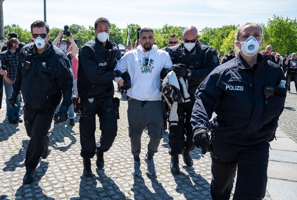 Attila Hildmann wird bei einer Demonstration vor dem Reichstagsgebäude von Polizisten abgeführt. Unter den Demonstranten sind viele aus der Szene der Verschwörungstheoretiker und der Reichsbürger.