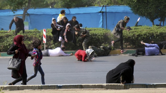 In this photo provided by Mehr News Agency, civilians try to take shelter in a shooting scene, during a military parade marking the 38th anniversary of Iraq&#039;s 1980 invasion of Iran, in the southw ...