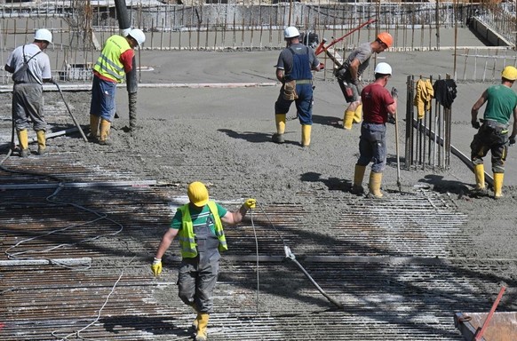 Construction workers pour concrete for residential buildings under construction at a large construction site in Munich, southern Germany, May 11, 2022. (Photo by Christof STACHE / AFP) (Photo by CHRIS ...