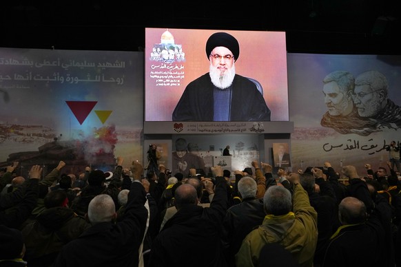 Supporters of the Iranian-backed Hezbollah group raise their fists and cheer, as they listen to a speech by Hezbollah leader Sayyed Hassan Nasrallah speaking via a video link during a ceremony to mark ...