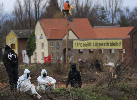 09.01.2023, Nordrhein-Westfalen, Erkelenz: Klimaschutzaktivisten sitzen am Dorfrand von Lützerath. Das Dorf Lützerath soll zur Erweiterung des Braunkohletagebaus Garzweiler II abgebaggert werden. Foto ...