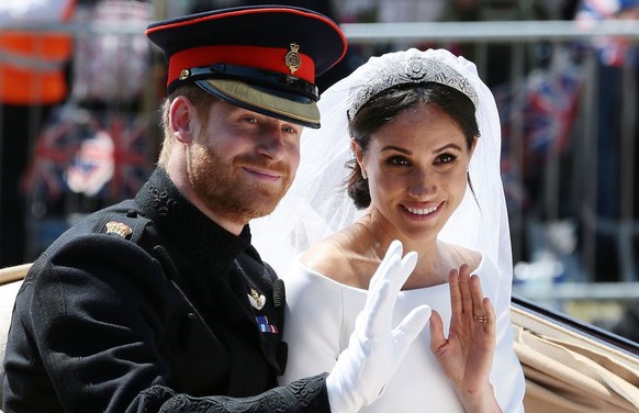 TOPSHOT - Britain's Prince Harry, Duke of Sussex and his wife Meghan, Duchess of Sussex wave from the Ascot Landau Carriage during their carriage procession on the Long Walk as they head back towards  ...