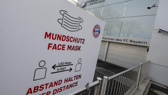 Das Logo des FC Bayern München und der Hinweis auf Mundschutz und Abstandsregel sind auf einem Schild am Hauptgebäude des Fußball-Vereins zu sehen. Vor Beginn des Trainingsauftakts beim Rekordmeister  ...
