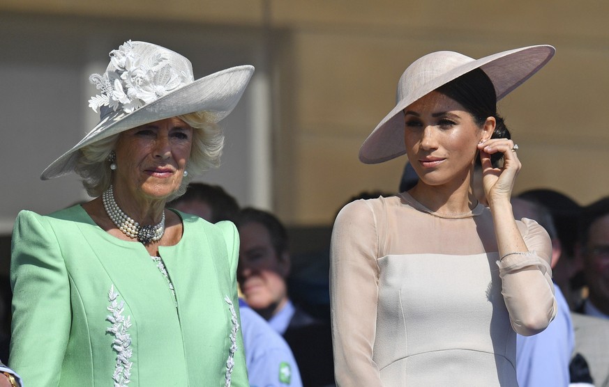 FILE - Meghan, the Duchess of Sussex, right, stands with Camilla, the Duchess of Cornwall, during a garden party at Buckingham Palace in London, Tuesday May 22, 2018. Britain&#039;s Prince Harry has d ...