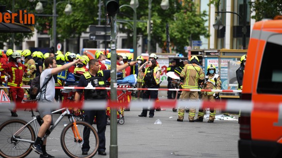 Einsatzkräfte stehen nach einem Zwischenfall auf der abgesperrten Straße. Ein Auto ist in der Nähe der Gedächtniskirche in Berlin in eine Personengruppe gefahren, ein Mensch ist gestorben. Das sagte e ...