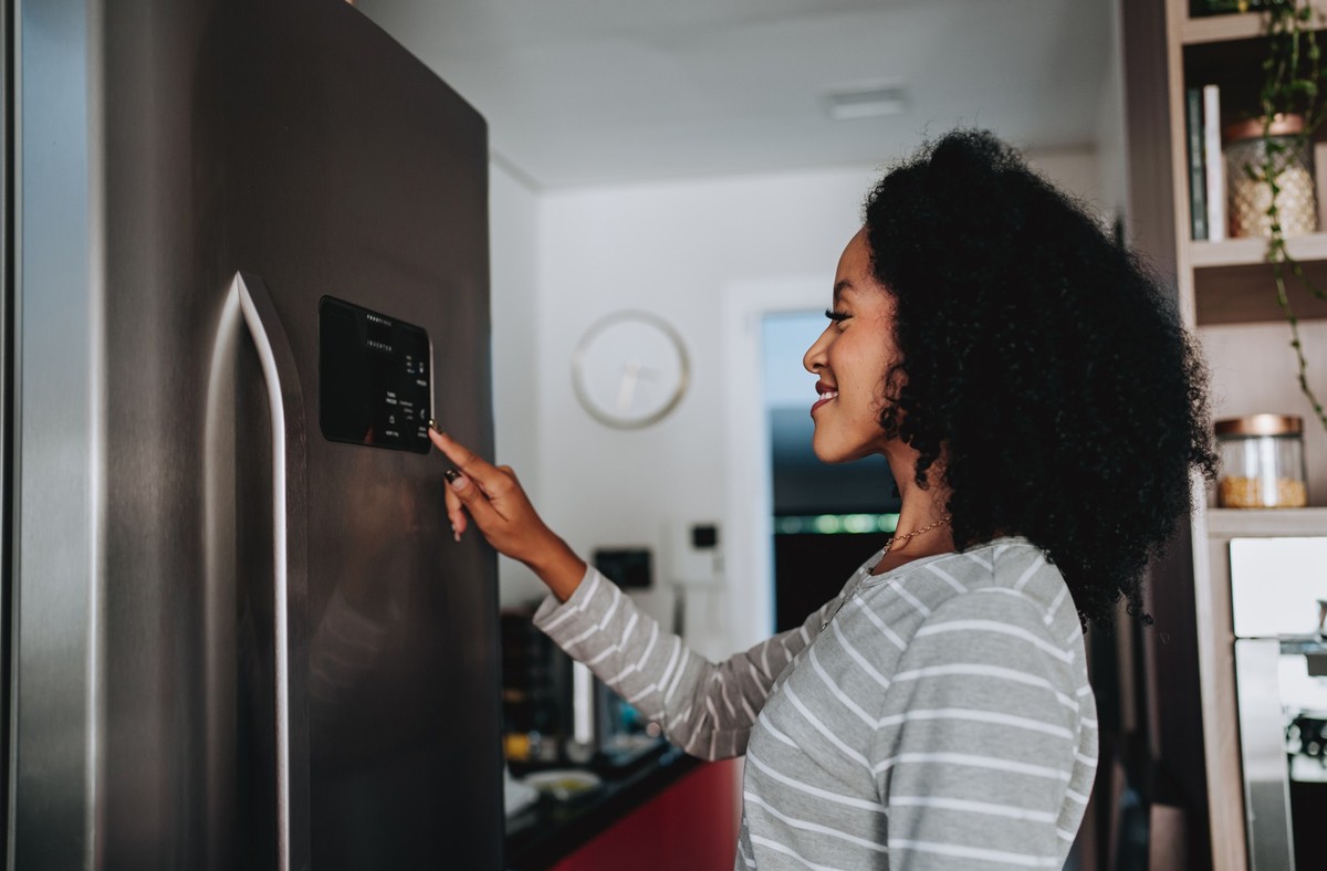 Woman using smart refrigerator checking information
