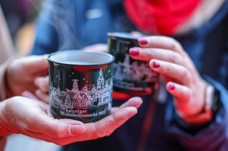 22.11.2022, Sachsen, Leipzig: Zwei Frauen stehen mit dampfendem Glühwein auf dem Leipziger Weihnachtsmarkt. Nach zwei Jahren coronabedingter Zwangspause gibt es in Leipzig wieder einen großen Weihnach ...