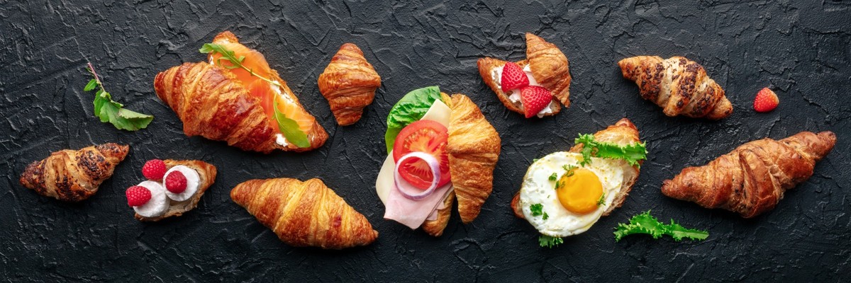 Croissant sandwich set panorama. Different stuffed croissants, overhead flat lay shot on a black slate background. Rolls filled with ham, salmon, egg, etc Model Released Property Released xkwx croissa ...