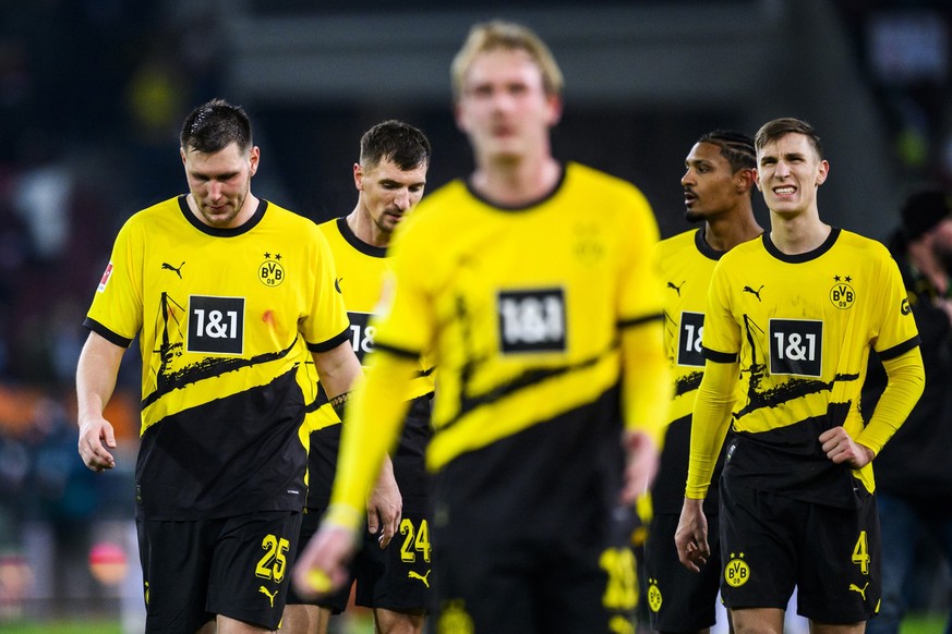 16.12.2023, Bayern, Augsburg: Fußball: Bundesliga, FC Augsburg - Borussia Dortmund, 15. Spieltag, WWK-Arena. Dortmunds Niklas Süle (l-r), Dortmunds Thomas Meunier, Dortmunds Julian Brandt, Dortmunds S ...