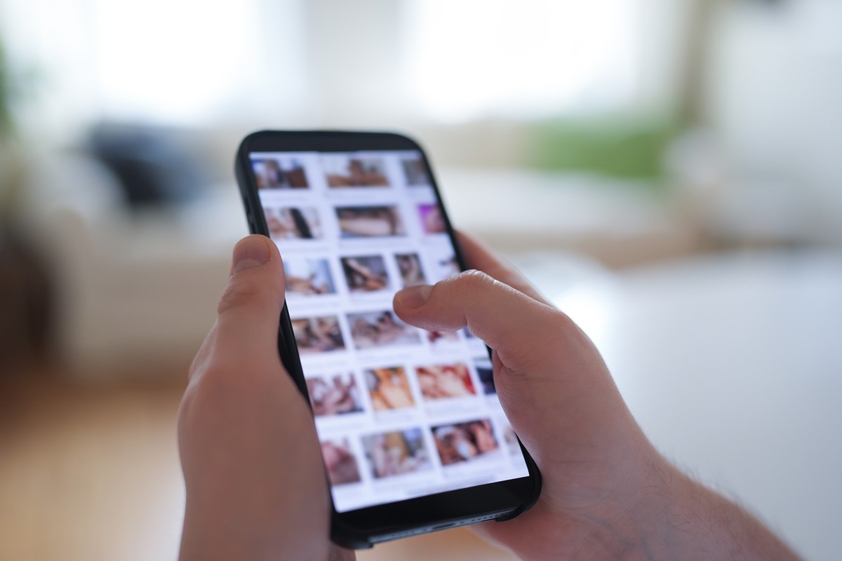PRODUKTION - 14.04.2025, Hamburg: ILLUSTRATION - Ein junger Mann schaut sich auf einem Smartphone eine Porno-Internetseite an (gestellte Szene). Immer mehr Frauen und M