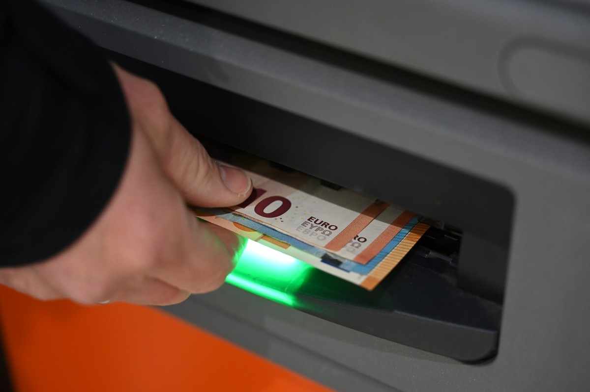 PRODUKTION - 12.03.2025, Sachsen, Leipzig: Ein Mann zieht Geldscheine aus dem Ausgabefach eines Geldautomaten (Symbolbild). (zu dpa: