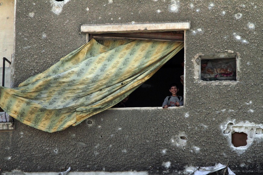 Ein Junge blickt aus einem Fenster in der zerstörten Stadt Duma. In der Stadt, in der Giftgas eingesetzt worden sein soll: Einige Überlebende machen die Rebellengruppe Dschaisch al-Islam (Armee des Is ...