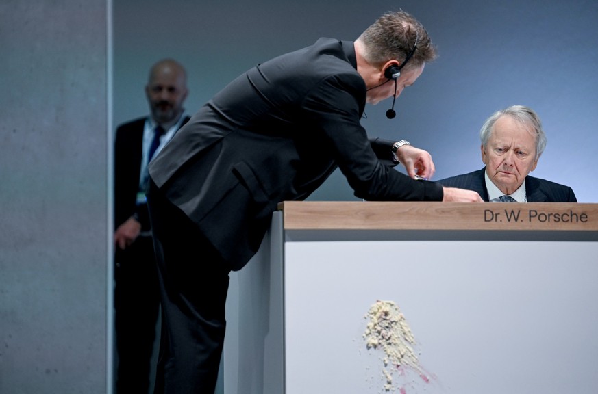 dpatopbilder - 10.05.2023, Berlin: Wolfgang Porsche, Vorsitzender des Aufsichtsrats der Porsche Automobil Holding SE, sitzt auf dem Podium, an dem man einen Abdruck nach einem Tortenwurf sieht, bei de ...