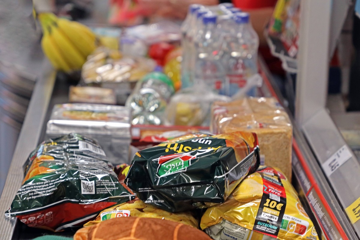Waren kurz vor der Bezahlung Lebensmittel und Haushaltswaren liegen auf einem Laufband zur Kasse im Supermarkt *** Goods just before payment food and household goods lie on a treadmill to the checkout ...