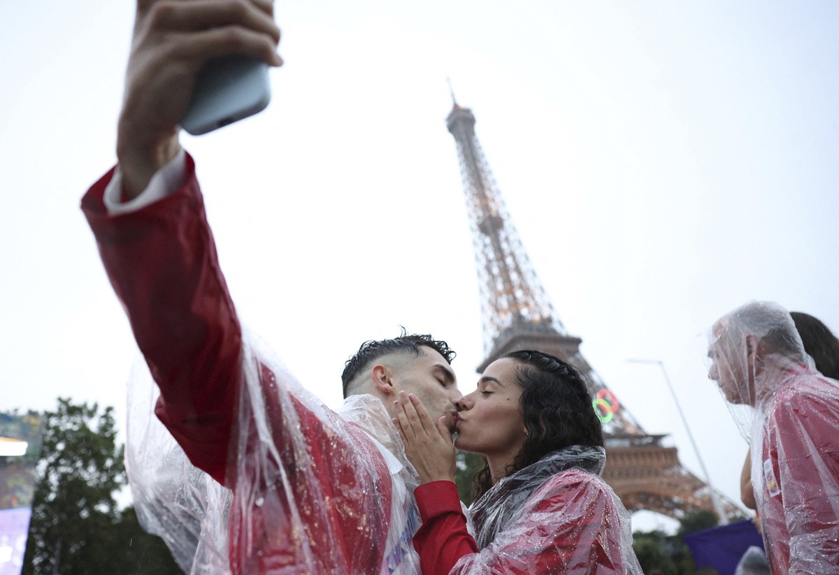 Spain athletes David Vega, left, and Noemi Romero kiss during the opening ceremony for the 2024 Summer Olympics, with the Eiffel Tower in the background, in Paris, France, Friday, July 26, 2024. (Viol ...