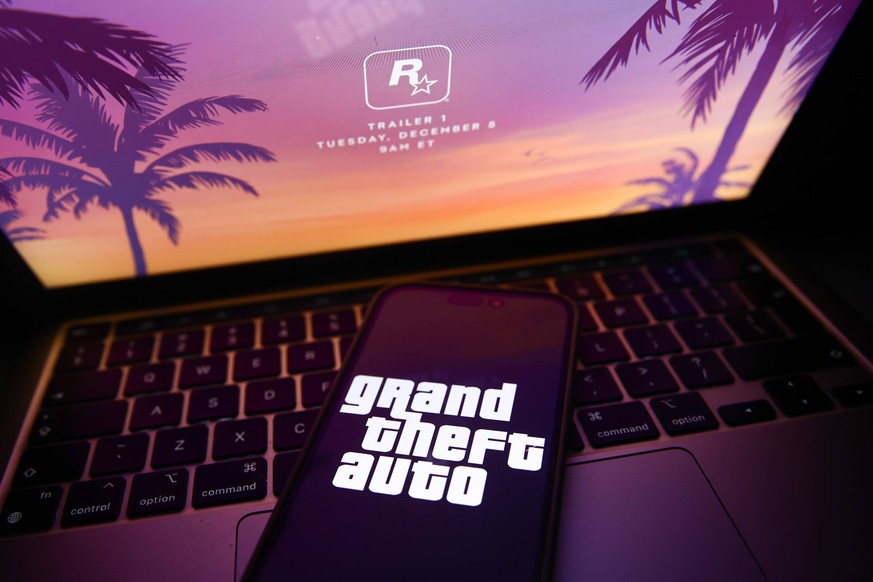Rockstar Grand Theft Auto Announcement Photo Illustrations Rockstar website announcing GTA 6 trailer displayed on a laptop screen and Grand Theft Auto logo displayed on a phone screen are seen in this ...