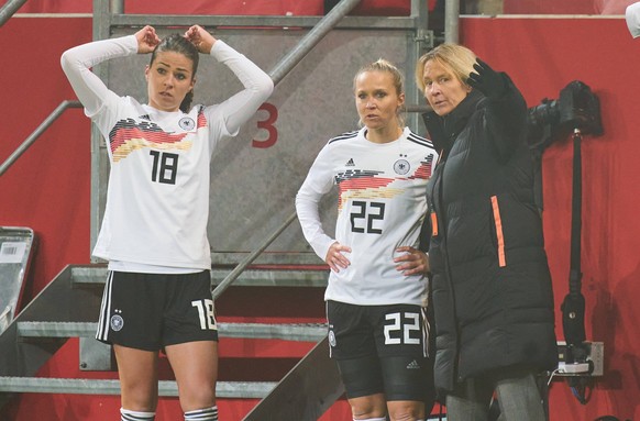 Turid Knaak (Nummer 22) und Melanie Leupolz (l.) bekommen Anweisungen von Bundestrainerin Martina Voss-Tecklenburg (r.).