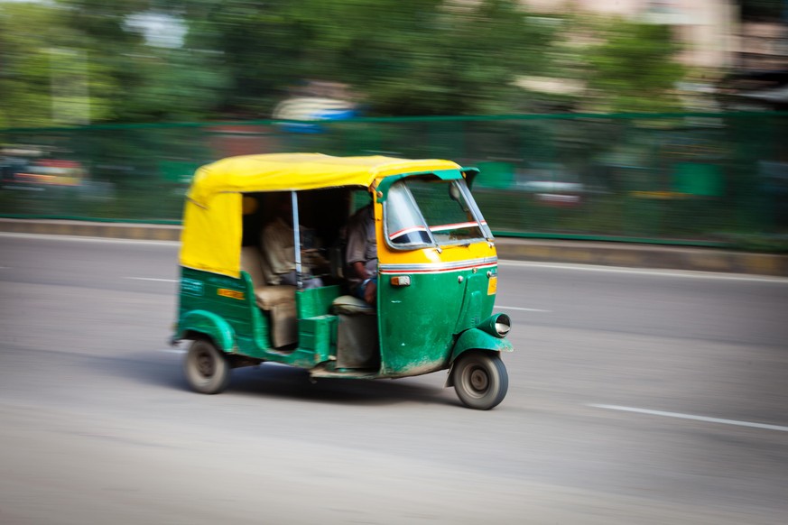 Indian auto (autorickshaw) taxi in the street. Motion blur. Delhi, India