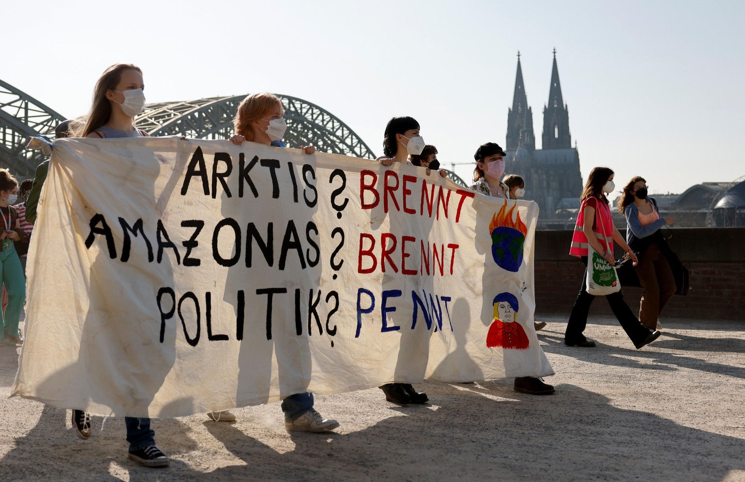 Demonstranten halten ein Transparent mit der Aufschrift: &quot;Arktis? brennt Amazonas? brennt Politik? pennt &quot; während des Klimastreiks von Fridays for Future in Köln Deutz. Beim globalen Klimas ...