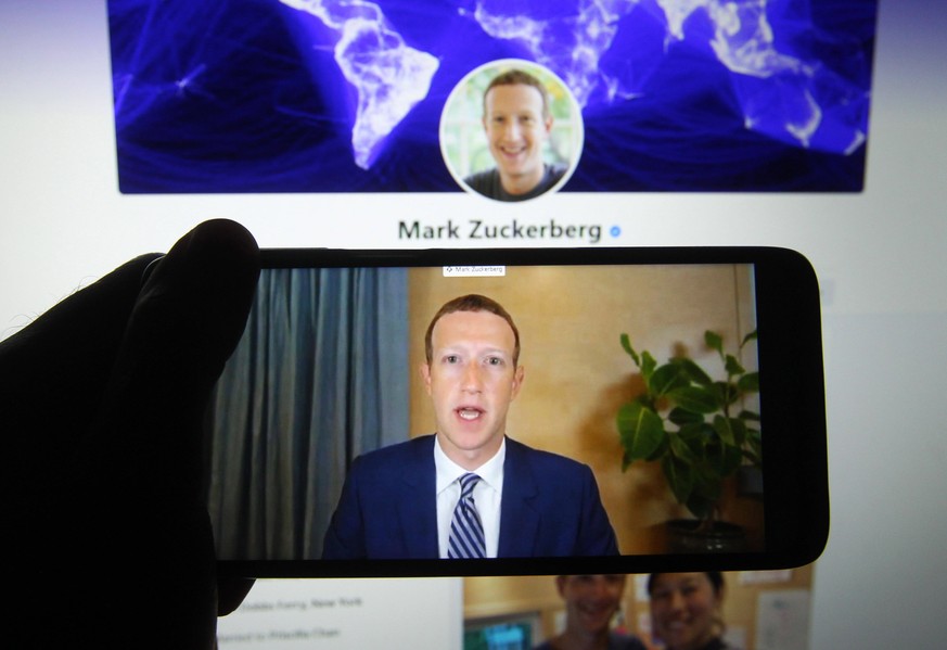 October 29, 2020, Kiev, Ukraine: In this photo illustration, Facebook CEO Mark Zuckerberg seen on a mobile screen as he remotely testify during the hearing of U.S. Senate Committee on Commerce, Scienc ...