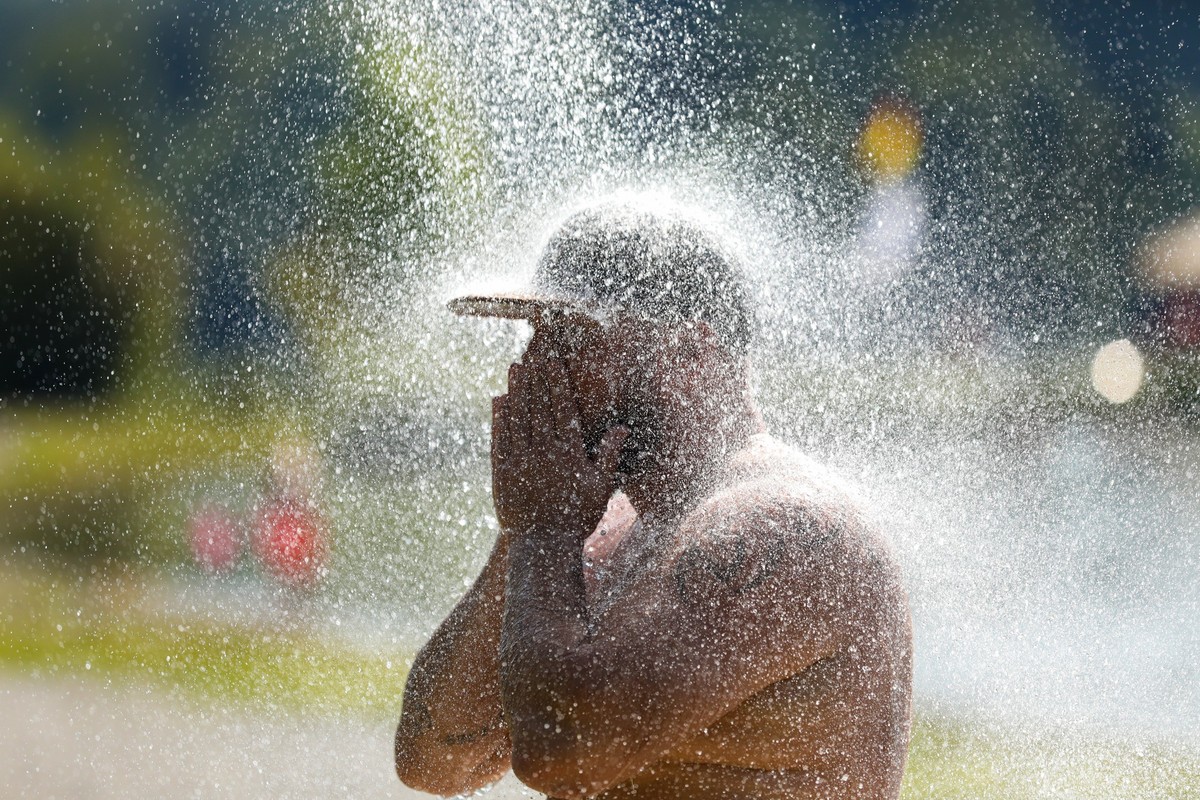 ARCHIV - 20.08.2023, Baden-Württemberg, Ertingen: Ein Mann erfrischt sich an einem Badesee unter einer kalten Dusche. Für den Tag waren Temperaturen über 30 Grad Celsius vorhergesagt. Noch nie war es  ...