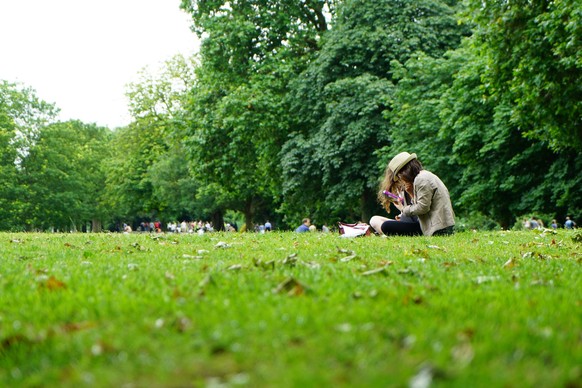 Pärchen sitzt im Stadtpark unter Bäumen