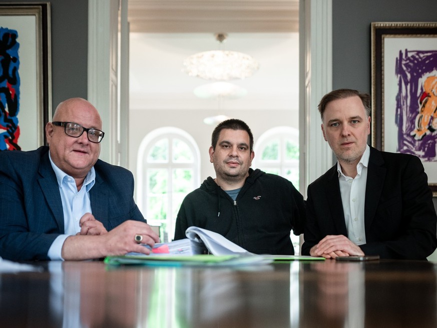 ARCHIV - 08.06.2022, Nrw, Wesel: Rechtsanwalt Dirk Giesen, Mandant Alexander B. und Rechtsanwalt Burkhard Benecken (l-r) sitzen in einer Kanzlei in Wesel. Audi hatte im vergangenen Jahr eine Unternehm ...