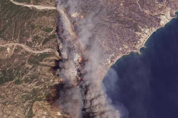 HANDOUT - 25.07.2023, Griechenland, Rhodos: Das von Planet Labs PBC zur Verfügung gestellte Satellitenbild zeigt das Ausmaß der Waldbrände auf einem Teil der Insel Rhodos. Starke Winde erschweren den  ...