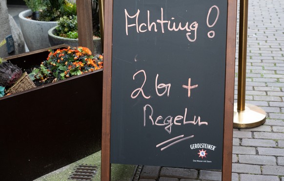 10.12.2021, Niedersachsen, Hannover: Ein Hinweisschild mit Aufschrift &quot;Achtung! 2G+ Regel&quot; steht vor einem Restaurant in der Innenstadt. Foto: Julian Stratenschulte/dpa +++ dpa-Bildfunk +++