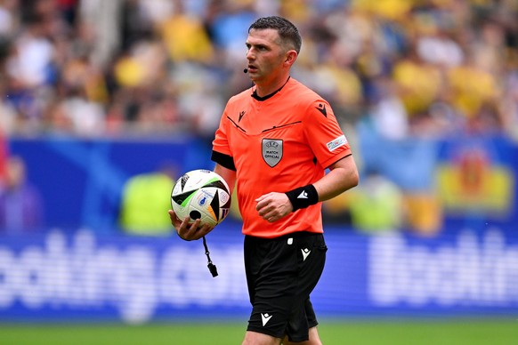 21 juni 2024, Noordrijn-Westfalen, Düsseldorf: Voetbal, UEFA Euro 2024, Europees Kampioenschap, Slowakije - Oekraïne, voorronde, groep E, speeldag 2, Düsseldorf Arena, scheidsrechter Michael Oliver met bal in de hand. Foto...