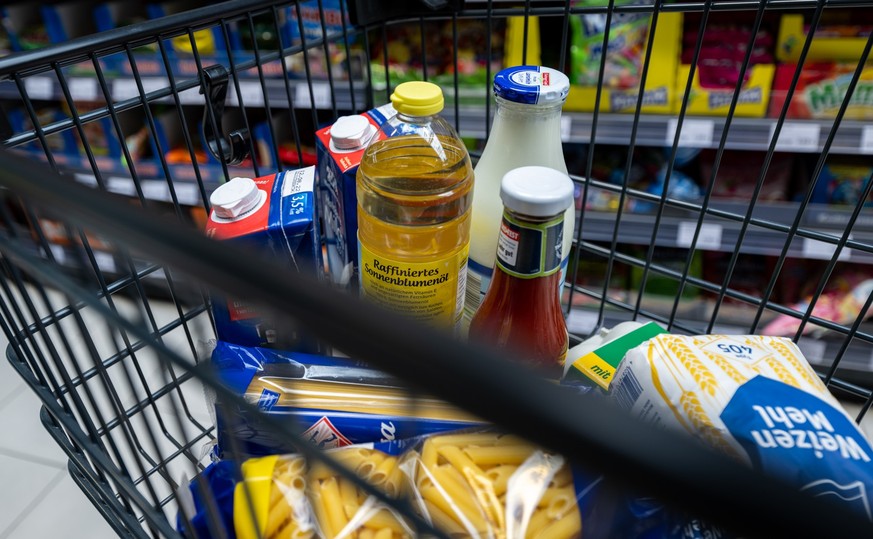 ARCHIV - 02.06.2022, Sachsen, Leipzig: Lebensmittel liegen in einem Einkaufswagen in einem Supermarkt. Trotz gestiegener Preise im Supermarkt steht die Ern