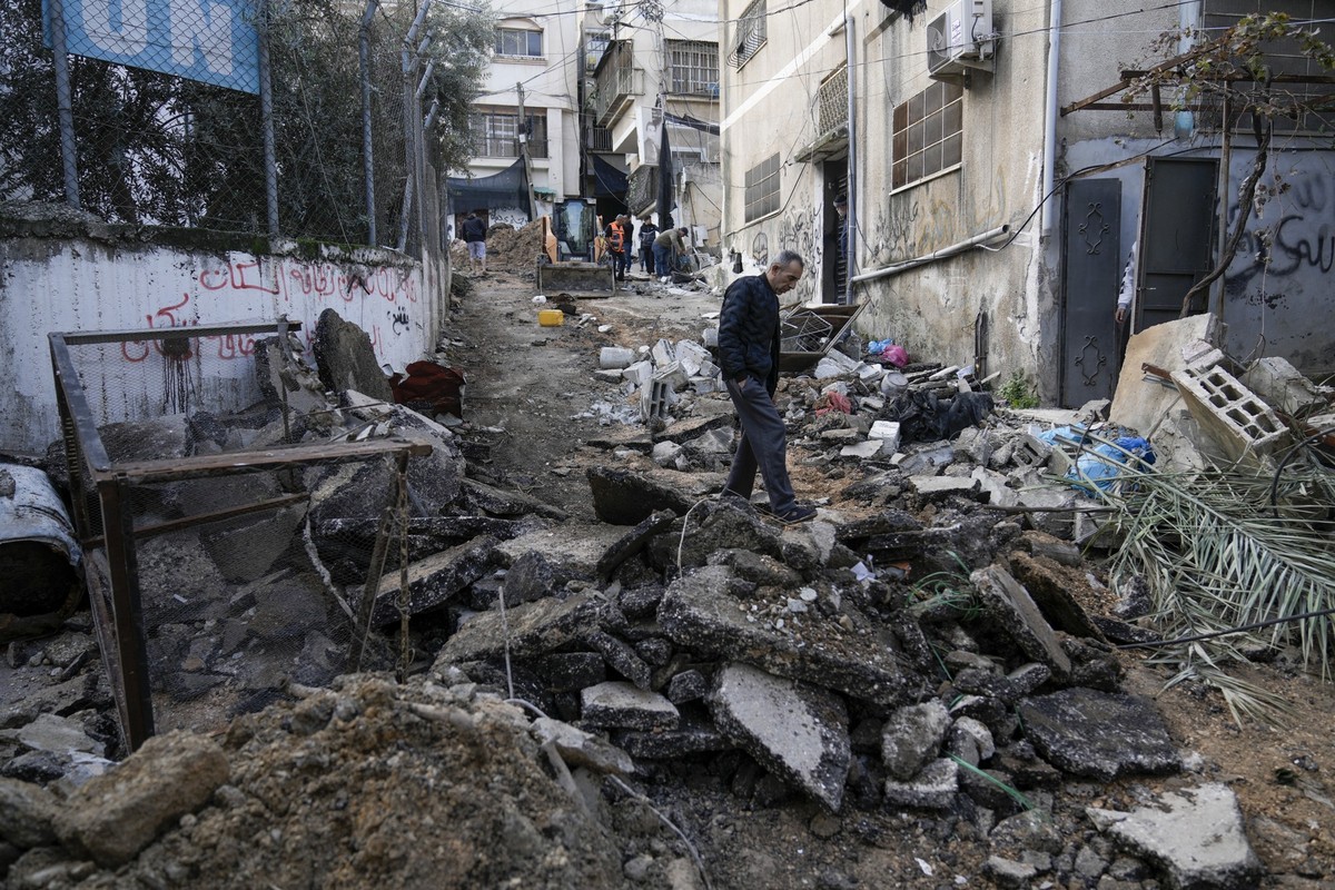 27.12.2023, Palästinensische Gebiete, Nur Schams: Palästinenser gehen durch Trümmer im Flüchtlingslager Nur Shams im Westjordanland. Bei einem israelischen Militäreinsatz in Tulkarem im Westjordanland ...