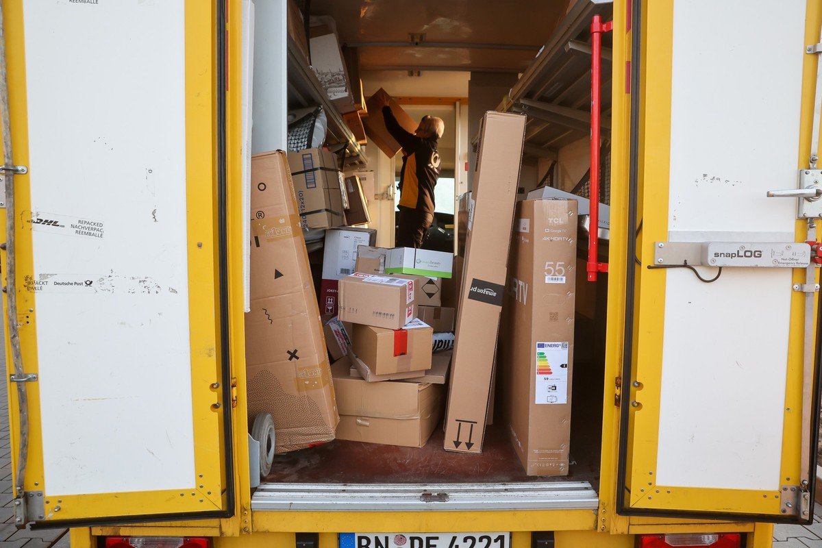 25.11.2022, Sachsen-Anhalt, Bitterfeld-Wolfen: Eine Mitarbeiterin der Deutsche Post DHL belädt ihr Fahrzeug mit Päckchen und Paketen. Die Wochen vor Weihnachten bedeutet traditionell Hochbetrieb bei d ...