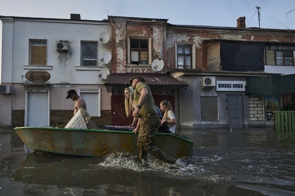 06.06.2023, Ukraine, Cherson: Rettungskräfte transportieren Bewohner mit Booten, die aus einem überfluteten Viertel in Cherson evakuiert werden sollen. Der russische Angriffskrieg gegen die Ukraine is ...