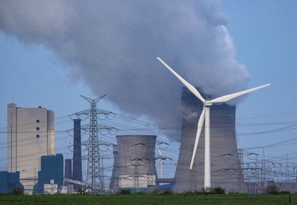 15.04.2024, Nrw, Grevenbroich: Dampf steigt aus dem RWE Braunkohlekraftwerk Neurath. Im Vordergrund steht eine Windkraftanlage. Der Expertenrat für Klimafragen veröffentlicht heute den Prüfbericht zu  ...